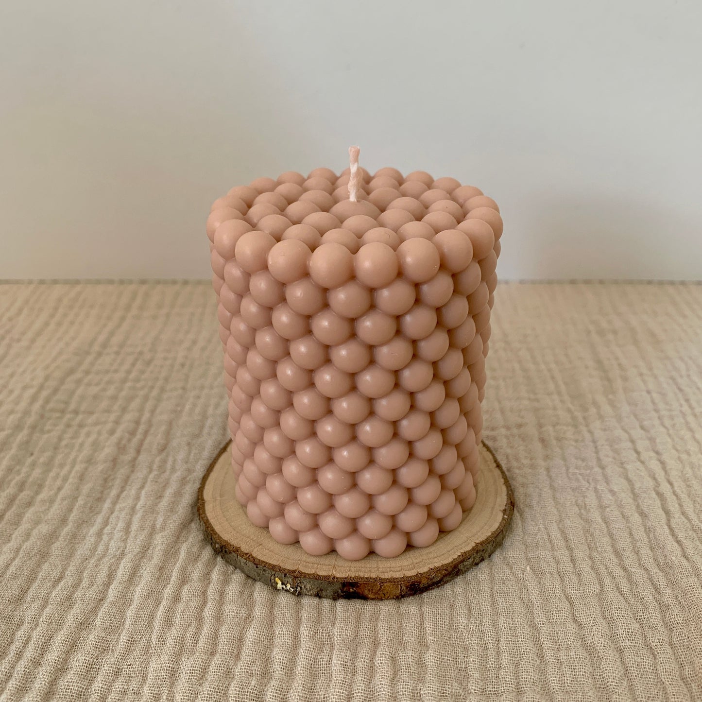 Beigefarbene runde Bubblekerze aus Rapswachs.
