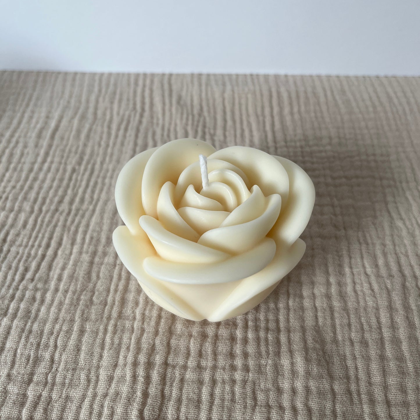 Große weße Rapswachskerze in Form einer Rose.