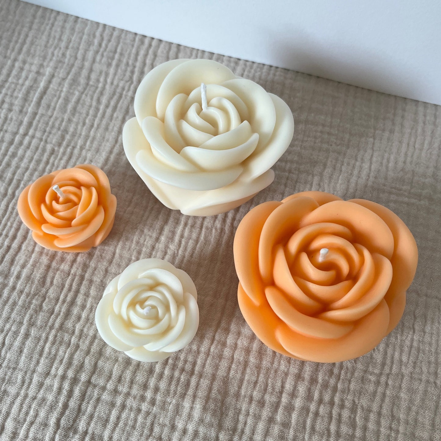 4er Set aus weißen und apricotfarbenen Rosenkerzen in klein und groß.