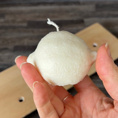 Zitronenkerze aus Rapswachs nach dem Ausformen aus der Silikonform in der Hand gehalten.