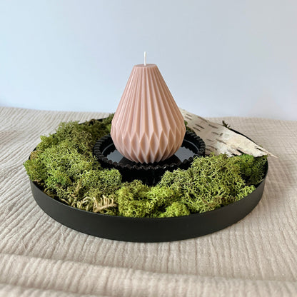 Beige Rapswachskerze Laterne auf einem schwarzen Teller mit Moos drumherum dekoriert.