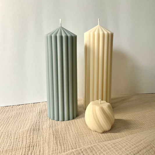 2 große Stumpenkerzen in weiß und hellblau.